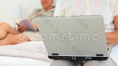 她丈夫正在看书的时候正在用笔记本电脑工作